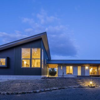 外観夕景。室内から漏れ出る光が美しい。外構はこれからだが、照明や階段など必要最低限のものは対応済だ
