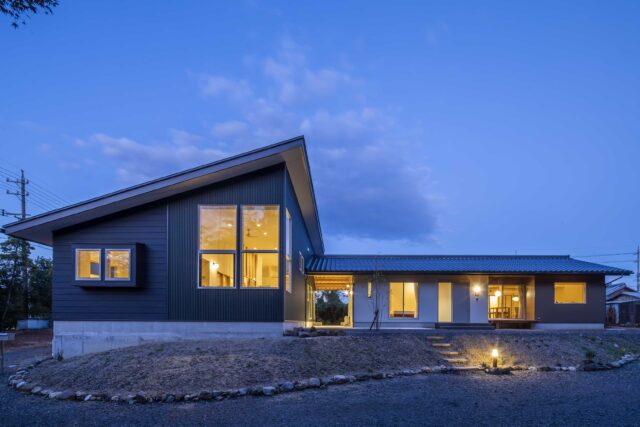外観夕景。室内から漏れ出る光が美しい。外構はこれからだが、照明や階段など必要最低限のものは対応済だ