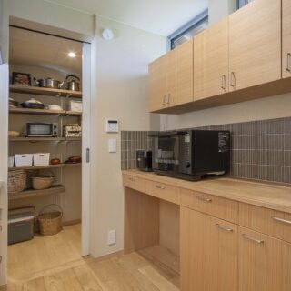 キッチン背後のタイルは、前住居のイメージで採用。パントリーは四日市の工芸品、萬古焼も収納できる広さだ
