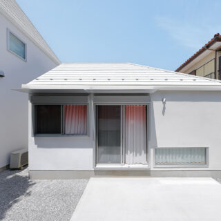 「Slur House」はコンパクトな平屋の離れ。母屋（写真左）の方に寄り添うような佇まいが微笑ましい。写真は南の庭から見た外観。庭は母屋と共用でき、バーベキューなども気軽に楽しめるように土間コンクリートで仕上げた。将来はウッドデッキを張ることも想定している
