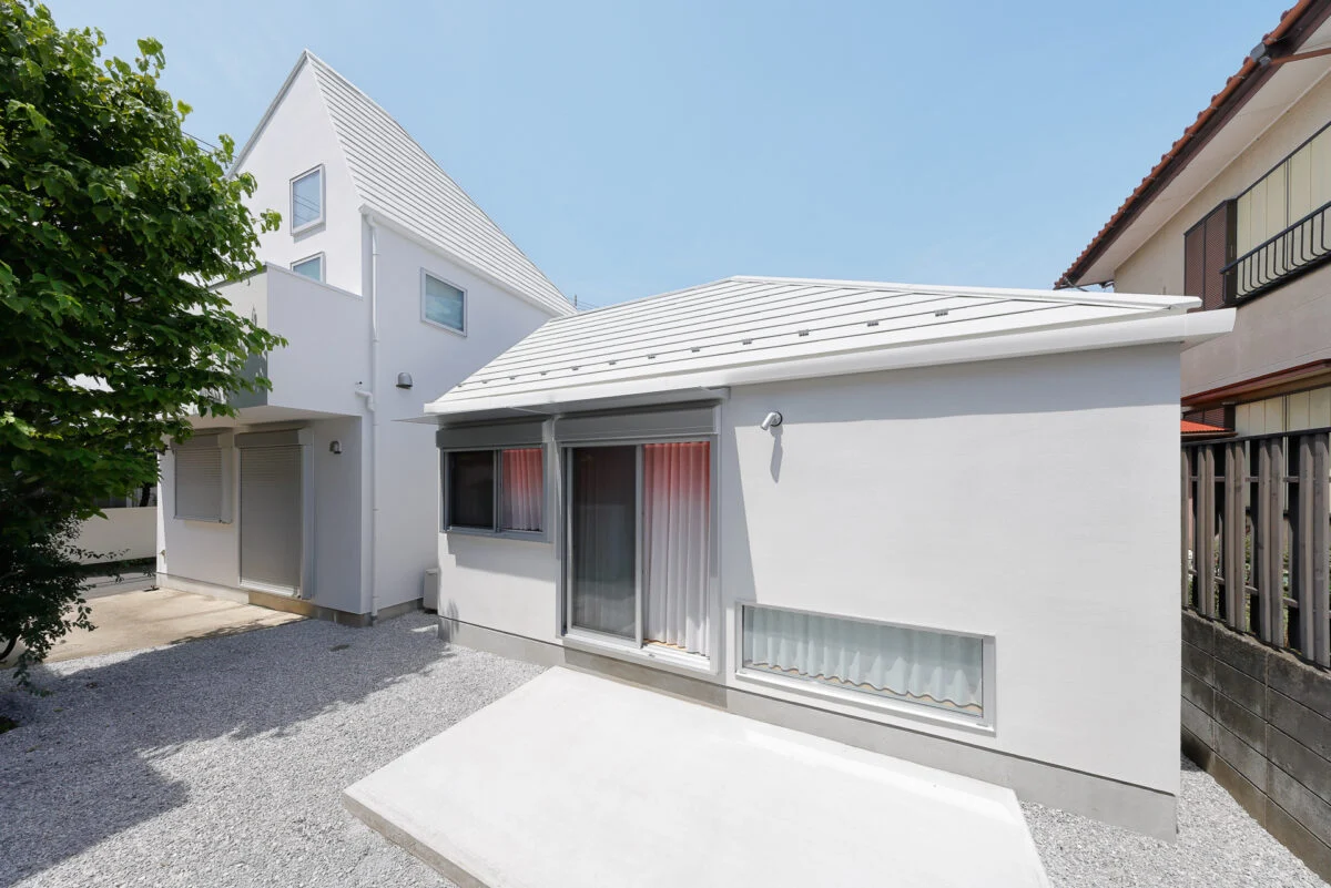 南側の庭からの外観は、母屋（写真左）と「Slur House」の2棟で1つの風景が完成するようにデザイン。建物のフォルムや屋根の形状、外壁の色などで母屋の特徴を引き継いだ「よく似ているけれどちょっと違う」デザインは、まさに親子のよう