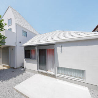 南側の庭からの外観は、母屋（写真左）と「Slur House」の2棟で1つの風景が完成するようにデザイン。建物のフォルムや屋根の形状、外壁の色などで母屋の特徴を引き継いだ「よく似ているけれどちょっと違う」デザインは、まさに親子のよう