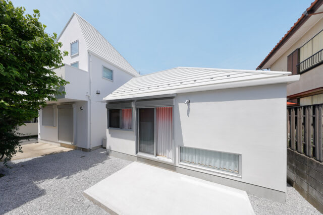 南側の庭からの外観は、母屋（写真左）と「Slur House」の2棟で1つの風景が完成するようにデザイン。建物のフォルムや屋根の形状、外壁の色などで母屋の特徴を引き継いだ「よく似ているけれどちょっと違う」デザインは、まさに親子のよう