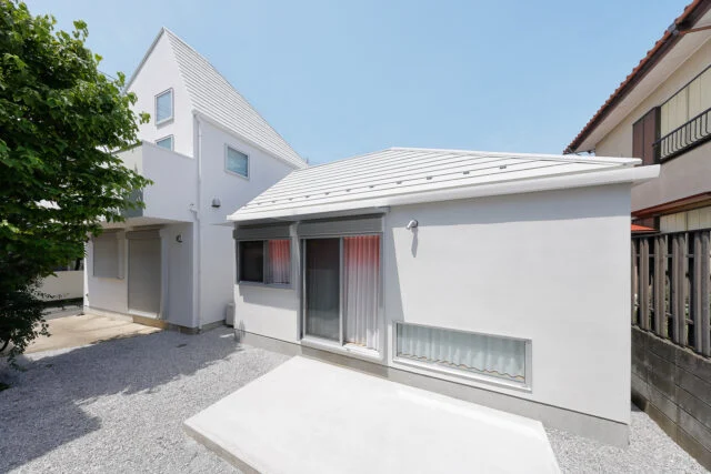 南側の庭からの外観は、母屋（写真左）と「Slur House」の2棟で1つの風景が完成するようにデザイン。建物のフォルムや屋根の形状、外壁の色などで母屋の特徴を引き継いだ「よく似ているけれどちょっと違う」デザインは、まさに親子のよう