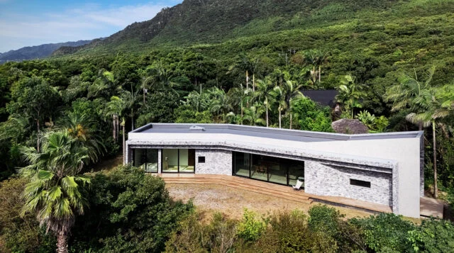 中央の大きな建物が「陽」エリアにある「RETREAT HOME」。建物の右には「陰」のエリアが広がっている。主寝室と浴室は右端に計画し、生い茂る緑と川が流れる音など、自然をより近くに感じられるようにした。RETREAT HOMEの奥、黒い三角屋根の建物は「GUEST PAVILION」