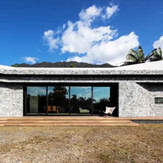 庭側から見た「RETREAT HOME」外観。建物はRC造。この地域では湿気で苔むしてしまうなど、外壁を美しく保つのが難しいという。そこで経年による変化が趣になる石壁を採用。あえて石をランダムに積んで自然な表情に。さらに大判タイルと組み合わせモダンな印象を演出した