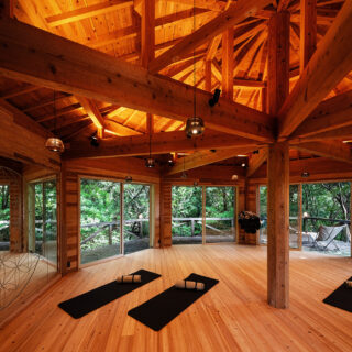 ヨガやイベント、セミナーなどを行う「MEDITATION PAVILION」は「陰」エリアに計画。既存の建物をリノベーションして梁を現しに、また床や壁なども一新した。外は手つかずの自然が広がる。画像左、ミラーのエッチングは島内加工できなかったため、他県で加工し運び入れた