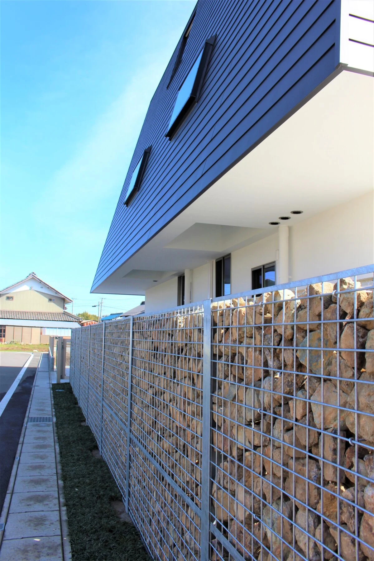 各務原産の石を詰め込んだ砕石擁壁。コンクリート壁のような圧迫感を排除しつつ外部からの視線を絶妙にカットし、吹き抜ける心地よい風だけを敷地内へと受け入れる設計。