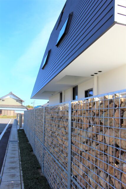 各務原産の石を詰め込んだ砕石擁壁。コンクリート壁のような圧迫感を排除しつつ外部からの視線を絶妙にカットし、吹き抜ける心地よい風だけを敷地内へと受け入れる設計。