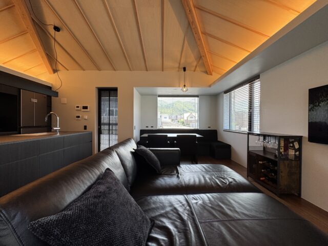札幌では珍しい寄棟の屋根を活かした、吹き抜けの天井。天井にはノイズになるダウンライトなどは設けず、内庇にダウンライトと間接照明を配置した