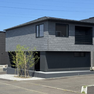 外観。2階が張り出し、札幌では珍しい寄棟屋根が目を引く。プライバシー確保のため、外側の窓は眺望を楽しむ最小限のものだけを配置。道路側の樹木も、大きく育つと目隠しになる位置に植えられている