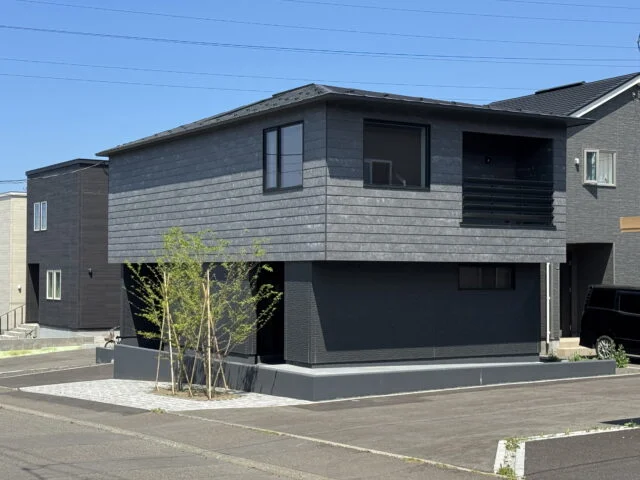 外観。2階が張り出し、札幌では珍しい寄棟屋根が目を引く。プライバシー確保のため、外側の窓は眺望を楽しむ最小限のものだけを配置。道路側の樹木も、大きく育つと目隠しになる位置に植えられている