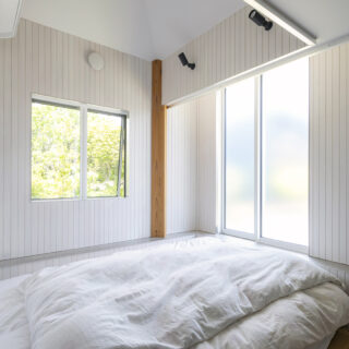 庭の緑が美しく、明るい寝室。現しの柱の向きに注目していただきたい。力のかかり方を計算すると、この作品の場合は通常の壁と平行なものではなく、45度回転させた方が合理的なのだという