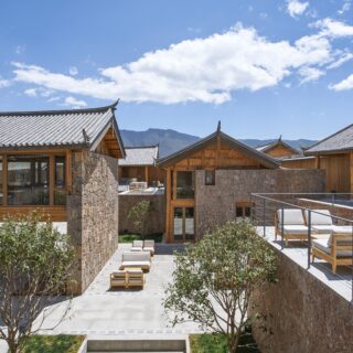 ランダムな石のボリューム群を設定しつつ規則的に屋根を配置することで、周囲との調和を図った外観。テラスとともに軒下の半屋外スペースも眺望を楽しむ空間として機能する