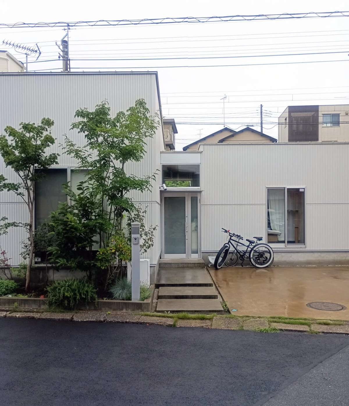 通り土間を中心に、寝室・水廻り棟とリビング棟を東西に配置したシンメトリーな構成。通り土間は外と内を緩やかにつなぐバッファとなり、東西棟を分ける“あいまいな空間”にもなっている