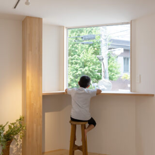 2階、主寝室には緑豊かな風景が眺められる大きな窓を計画した。カウンターを設け、居場所のひとつに