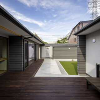 屋根を中庭側に低く抑えたことで、囲まれている圧迫感がない。見上げれば空が大きく広がる。ウッドデッキと人工芝が敷かれ、家族が過ごす場として設えられている。