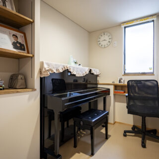 奥様が趣味でピアノを弾くための一室。扉は防音仕様としている。造作のカウンターも設えた。
