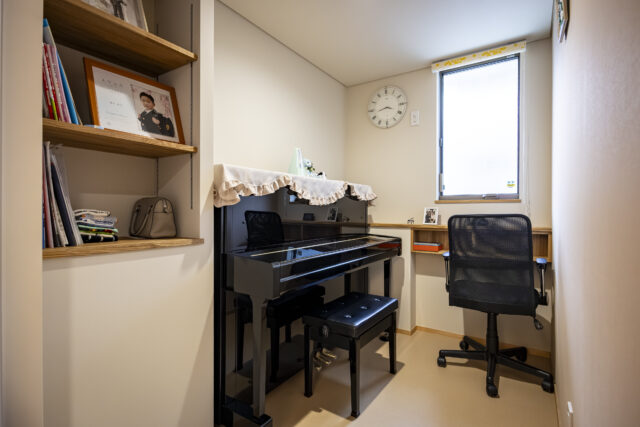 奥様が趣味でピアノを弾くための一室。扉は防音仕様としている。造作のカウンターも設えた。