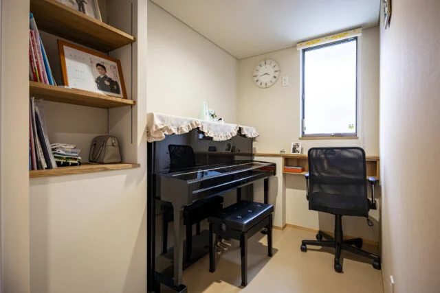 奥様が趣味でピアノを弾くための一室。扉は防音仕様としている。造作のカウンターも設えた。