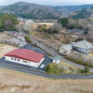 西側からの外観全景。周囲の風景と調和するよう一枚の大きな屋根で覆うデザインを採用した。集会室の高さを確保するためのアシメトリーなフォルムにより、おおらかで心地よいリズムが生まれた