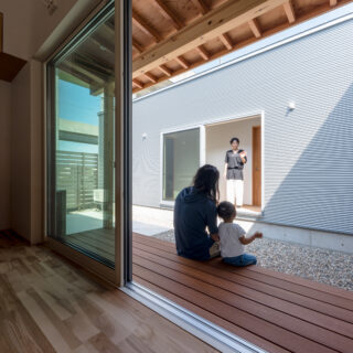 プランの核となる中庭。ここでコミュニケーションを取ることを想定して設計された。リビング側にはウッドデッキを設置。長く伸ばした庇もあるので、天候の影響を受けずにくつろぐことができる