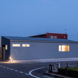 外観夕景。車が曲がる際の視線確保を考え、外構はシンプルで高い樹木などは植えていない。安全への配慮だ