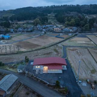 室内に明かりが灯った夕景。屋根材にはガルバリウム鋼板を採用