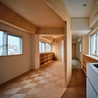 写真中央が正円の軌道に乗る仕切り壁。この曲線の壁の内側（写真左）は用途を限定しないフリーな「広間」として夫婦で共用。その背後（写真右）には、住宅としての機能を担う水まわりや個室を配している