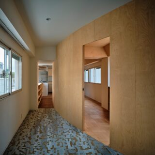 奥さまの個室からキッチン（写真奥）を見る。曲線を描く壁は、空間の広さにメリハリがついて床面積を効率よく使えることがメリット。狭くなった中間部は家具置き場や通路として無駄なく使える