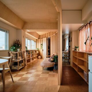キッチンから広間（写真左）を見る。正円の壁で囲われた広間は眺めの良い南西に窓が連続しており、明るい自然光がたっぷり入って居心地抜群。円弧を描く壁のおかげで中央部にはソファやテーブルをゆったり置ける広さを確保でき、Mさん夫妻のお気に入りスペースになっている