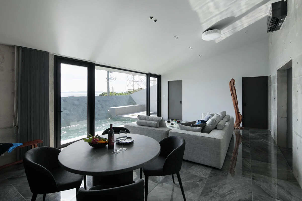 外観の特徴ともなっている屋根は、海とプールに向かって下げられている。視線をぐっと景色へ絞り込む設計。開放感を優先しがちな別荘建築において、あえての一手だといえる。