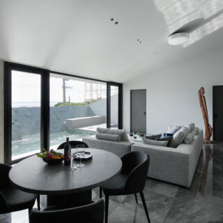 外観の特徴ともなっている屋根は、海とプールに向かって下げられている。視線をぐっと景色へ絞り込む設計。開放感を優先しがちな別荘建築において、あえての一手だといえる。