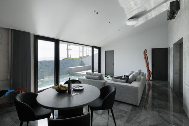 外観の特徴ともなっている屋根は、海とプールに向かって下げられている。視線をぐっと景色へ絞り込む設計。開放感を優先しがちな別荘建築において、あえての一手だといえる。