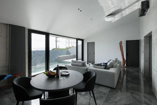 外観の特徴ともなっている屋根は、海とプールに向かって下げられている。視線をぐっと景色へ絞り込む設計。開放感を優先しがちな別荘建築において、あえての一手だといえる。