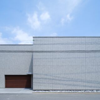 窓のない外観が印象的なI邸。プライバシーの確保とスタジオの音を漏らさない防音性を持たせた。２台分のビルトインガレージも完備。　