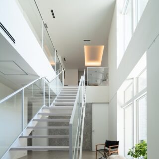 天に昇っていくような階段室。上部を塞がず大きな窓とすることで、光が降りてくる。単なる動線ではなく、ホールとして空間化された。階段にゆとりを持たせたいという考えが、2階建てを提案した理由のひとつでもある。
