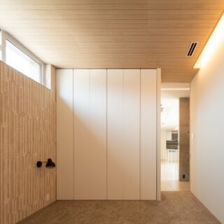 壁はエコカラット、その上部には突板パネルを用い、床にはカーペットを敷いた。他の空間とは温度感を変え、温かみのある落ち着いた雰囲気に。当初の要望は1部屋だったが、2部屋に変更された数少ない設計変更のひとつだ。