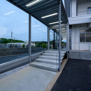 緩やかなスロープや増築部の緩やかな段差とあわせ、入り口の階段部もかなり緩やかなものとした。外と中の連続性を持たせた意匠だ。歩行する際の安定性や安心感、緩やかな表情を入り口に持たせる意図もある