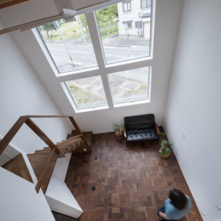 2階の部屋に設置された小窓から見たリビング。窓から外の緑を楽しめ、リビングにいる人の気配も感じられる
