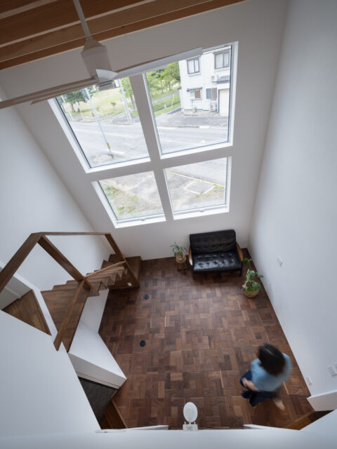 2階の部屋に設置された小窓から見たリビング。窓から外の緑を楽しめ、リビングにいる人の気配も感じられる