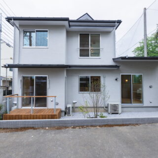南側からの外観。左右で高さを変え、東側の1階を出窓のように前へ出す。斜線制限と階高から生まれる背の高さを、屋根と軒の操作で和らげ2つの家が重なったような佇まい