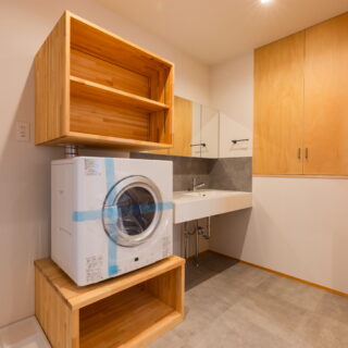 洗面室にはガス衣類乾燥機を設置。乾かしたものをその場でしまえる。洗面横には、階段上の空間を利用した収納も