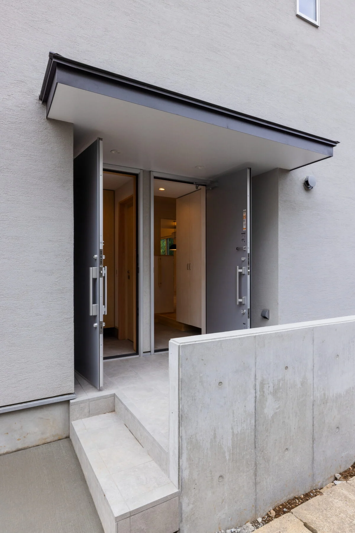 玄関には同じ扉が2つ並ぶ。右が1階、左が2階への入口。それぞれの住まいが、外から独立している