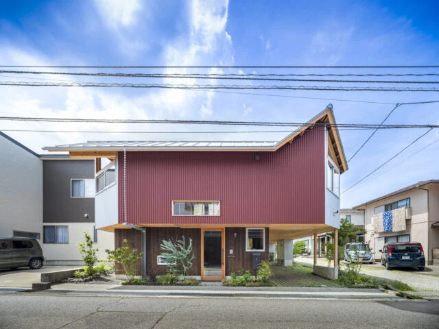 口の字型の建物の角を切り落とし、街並みにつながる視線を確保したユニークな外観。周囲の建物の屋根形状に自然な形で呼応するよう、切妻屋根と片流れの屋根を立体的に組み合わせてデザインした